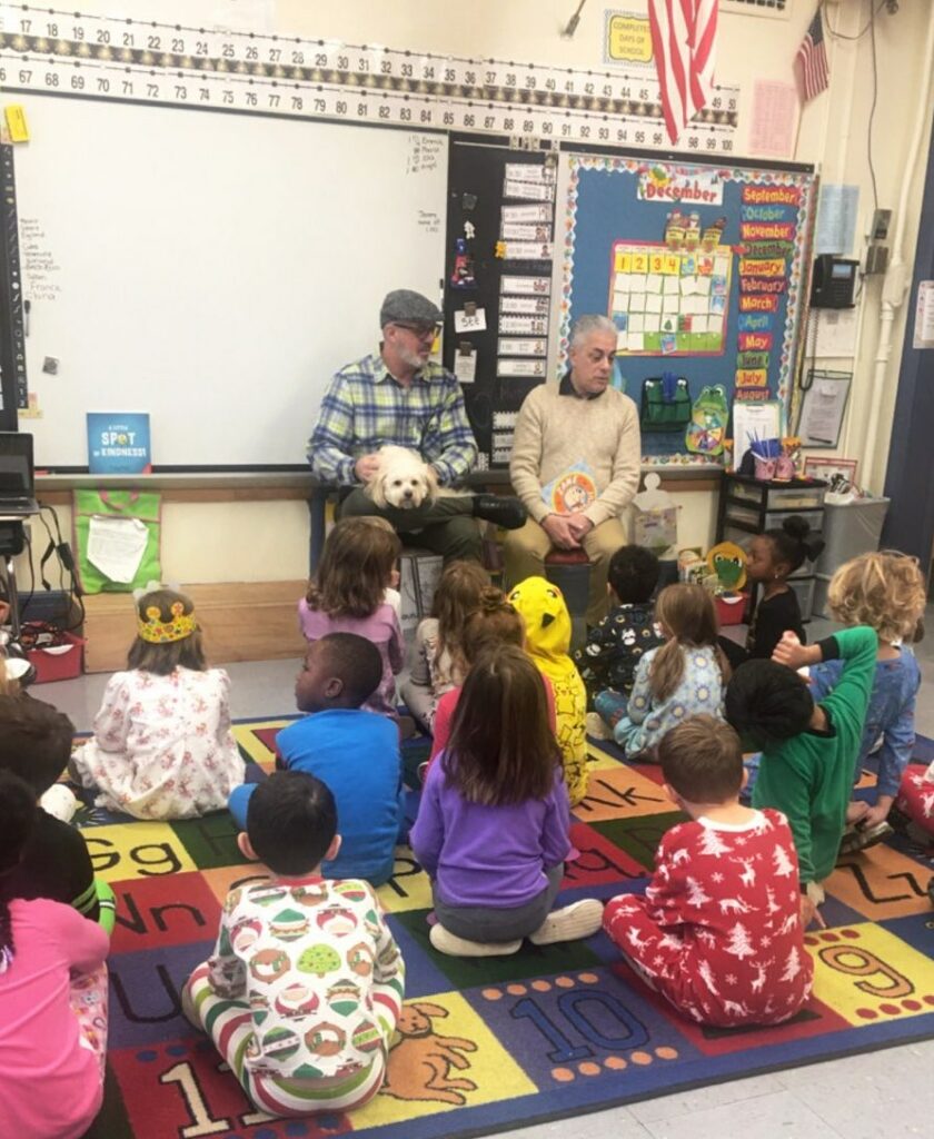 Larry, Zane, and James reading "Zane to the Rescue" to schoolchildren 